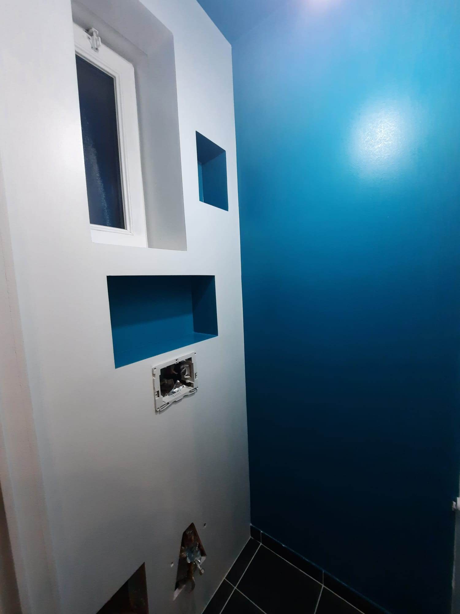 Mur à niches repeint en bleu pétrole et blanc