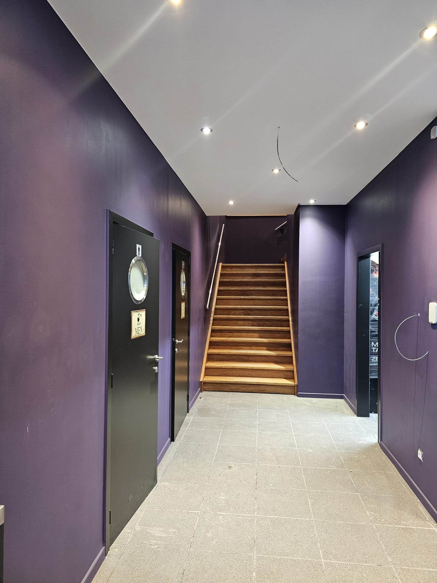 Couloir repeint en violet profond, portes noires